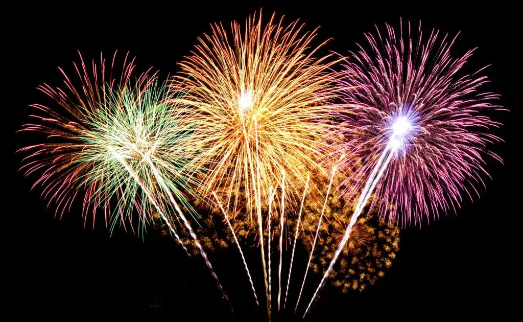 Multi-colored rocket fireworks launching into sky